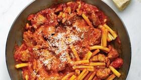 Grønnsaksaus med biter, som dekker en kjele med kokt pasta