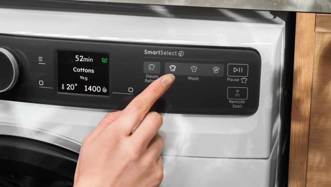 Hånd som justerer innstillingene på en vaskemaskin fra Electrolux.