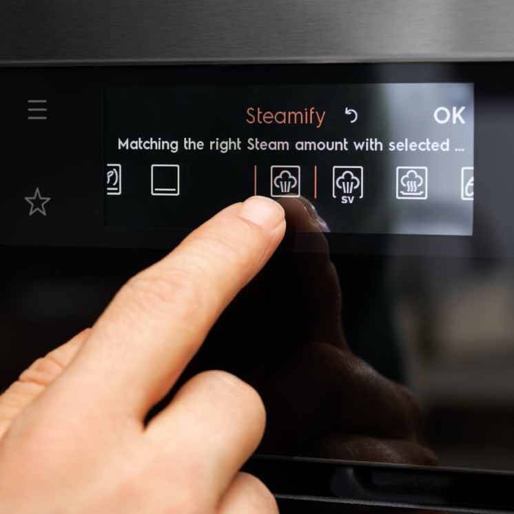 Finger på kontrollpanelet på en dampovn