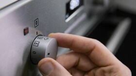 En baker setter ovnen til PlusSteam-innstillingen, klar for vaniljesausen