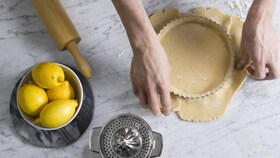 Electrolux-baker fyller nøye paiformen tinn med deig
