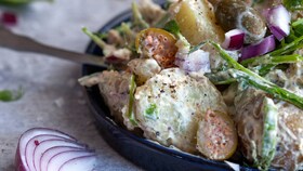 En deilig potetsalat blandet med majones, urter og rødløk