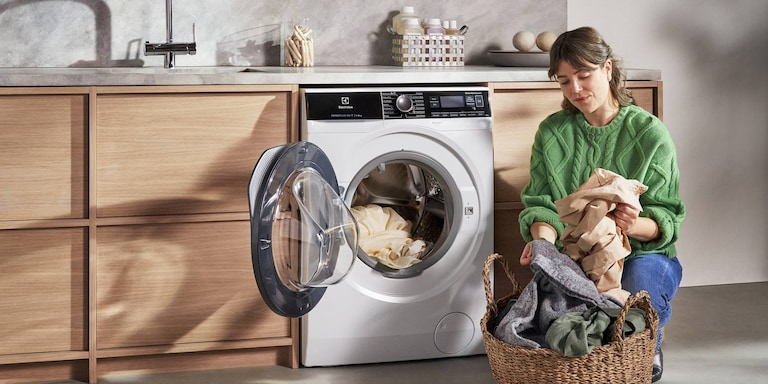 Kvinne tømmer vaskemaskinen