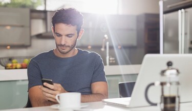 mann scroller på sin telefon