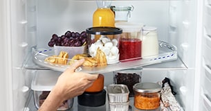 Hand taking out tray from fridge