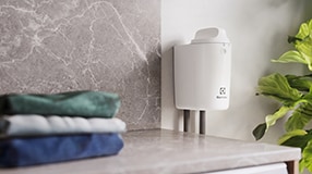 brettede klær oppå en vaskemaskin