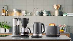 kaffetrakter, vannkoker og en toaster på en kjøkkenbenk