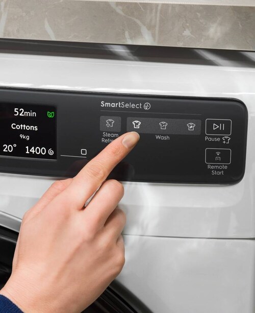 En person justerer innstillingene på en Electrolux vaskemaskin.