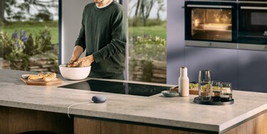 Hands in bowl and Google Assistant on countertop
