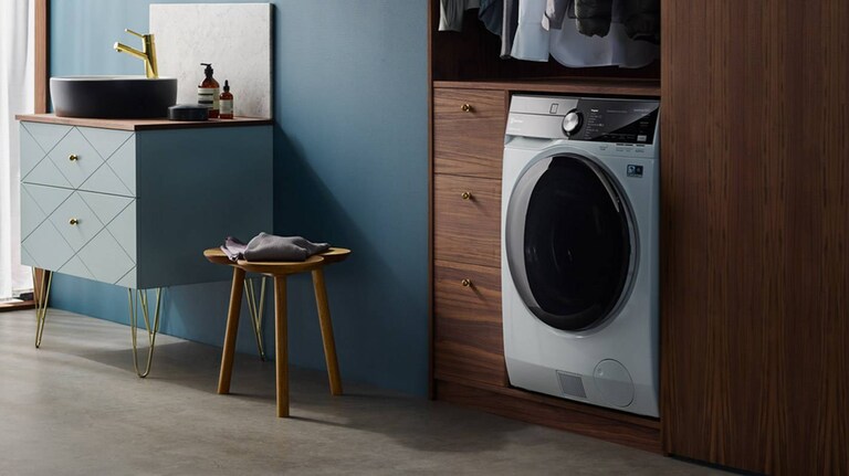 En vaskemaskin med tørketrommel står på et stilfullt bad.