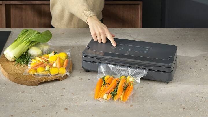 Gulrøtter blir vakuumpakket med en vakuumpakker før tilberedning.