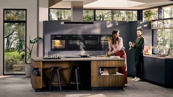 En mann og en kvinne lager mat på et kjøkken.