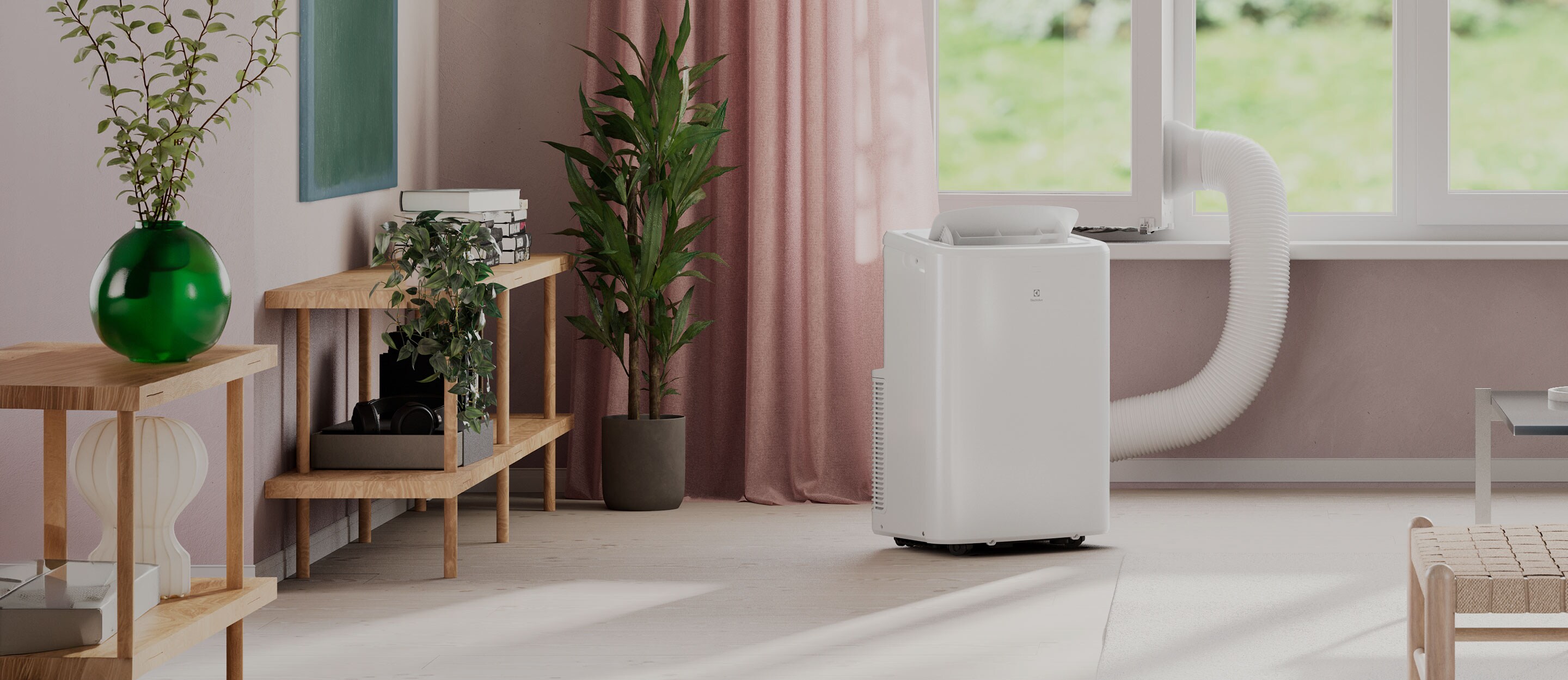 Kompakt og bærbar Electrolux aircondition for plassering ved vindu. Den kjøler rommet effektivt og leder bort varm luft via slange.