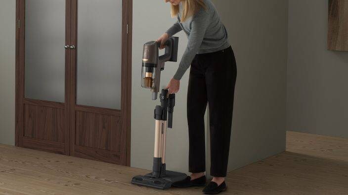 En kvinne skal støvsuge med en oppladbar støvsuger.