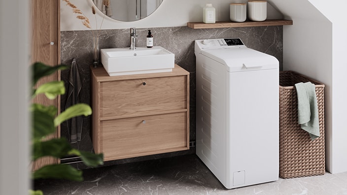 En toppmatet vaskemaskin er plassert på et moderne bad.