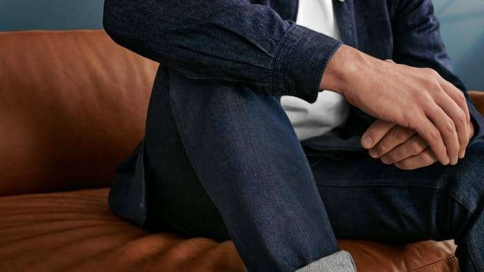 En mann sitter i en sofa